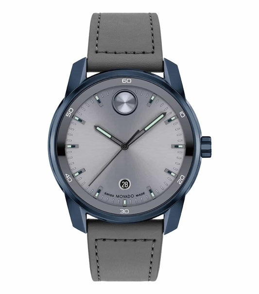 Movado watch in bold blue, angled slightly left, showcasing sleek design and silver accents; timepiece elegance and craftsmanship.
