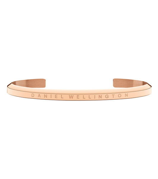 Elegant Daniel Wellington rose gold bracelet cuff, angled on a white backdrop, showcasing sleek minimalistic design and timeless charm.