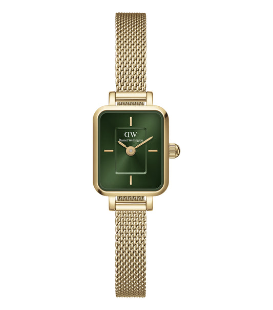 Daniel Wellington Quadro watch in a classic gold finish, captured at a slight angle with a minimalist white dial on beige background.