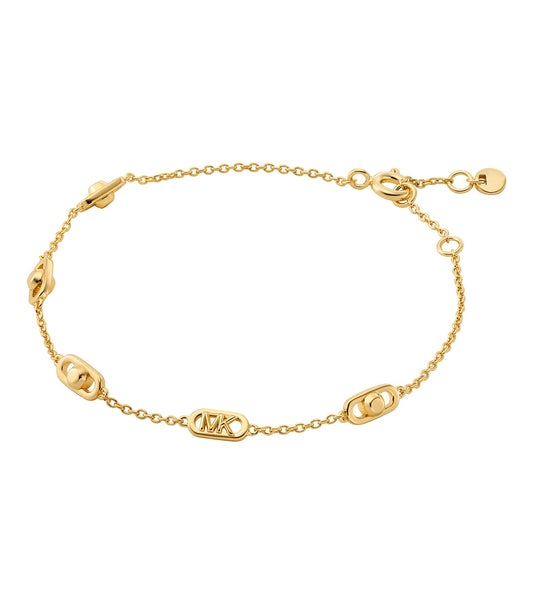 Michael Kors gold bracelet displayed at an upward angle, showcasing its luxurious shine and elegant design against a dark background.