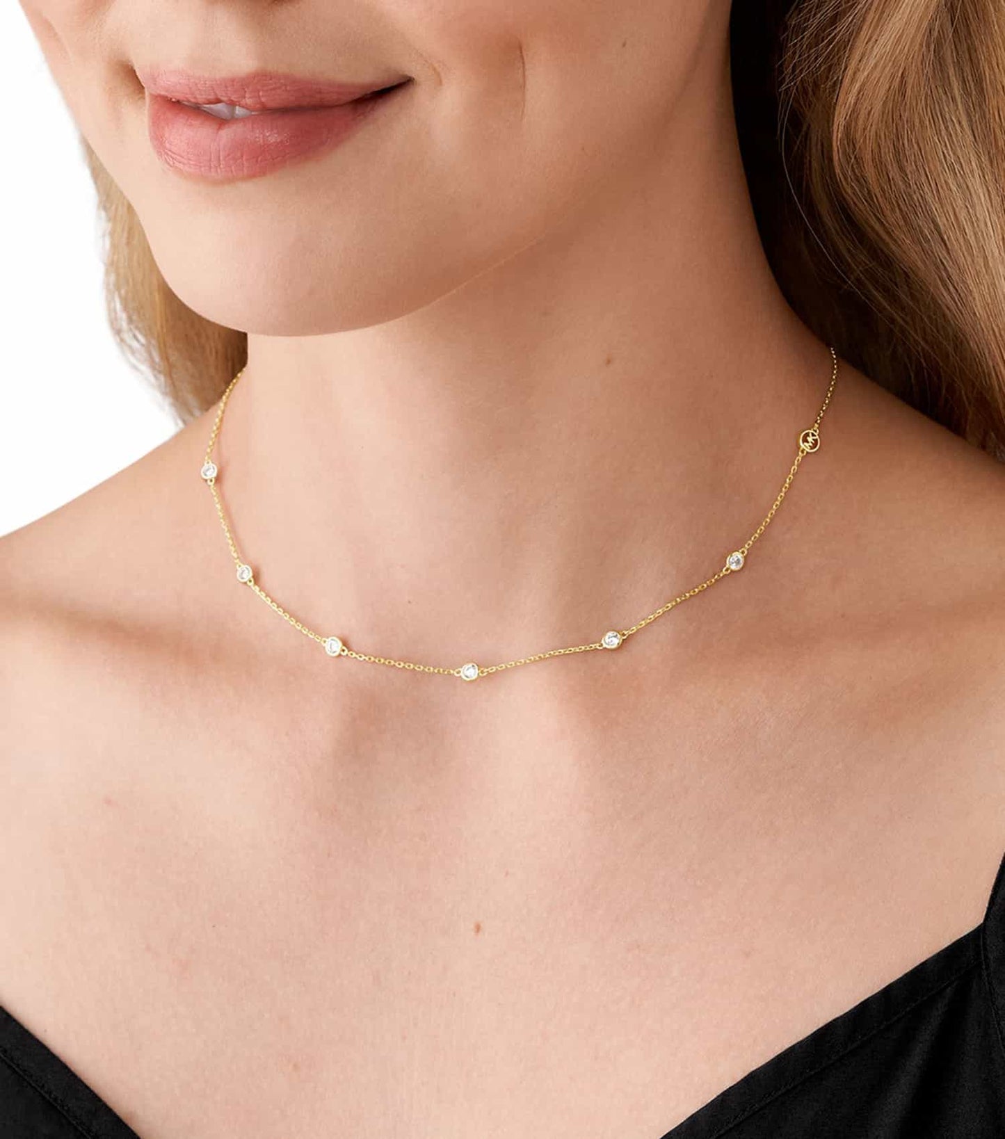 Michael Kors gold-colored necklace with elegant crystal accents, angled front view, showcasing refined luxury and craftsmanship.