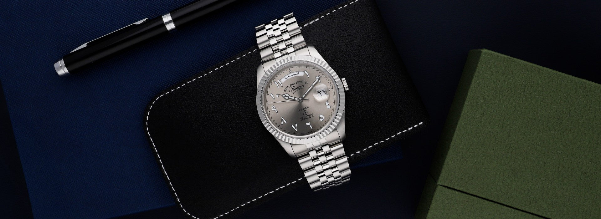 West End Watch Co men's automatic watch featuring a silver Arabic dial, date display and stainless steel bracelet.
